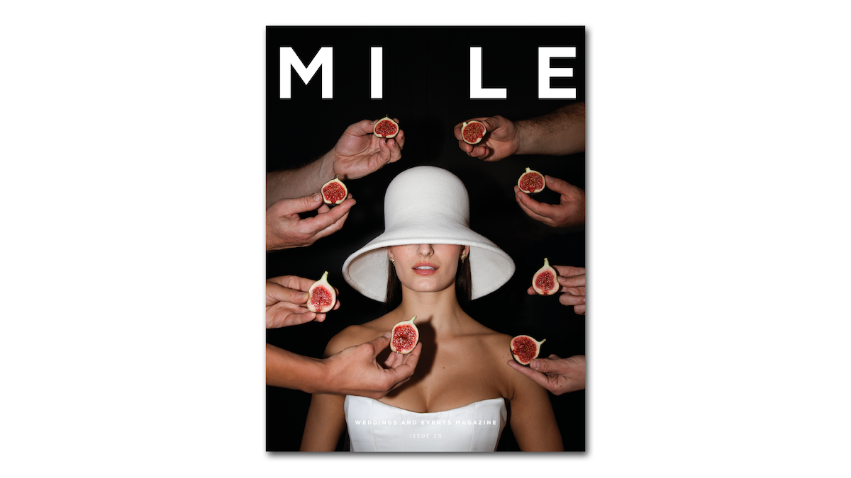 Magazine cover with a woman in a white hat surrounded by hands holding figs, brand 'MILE' visible.